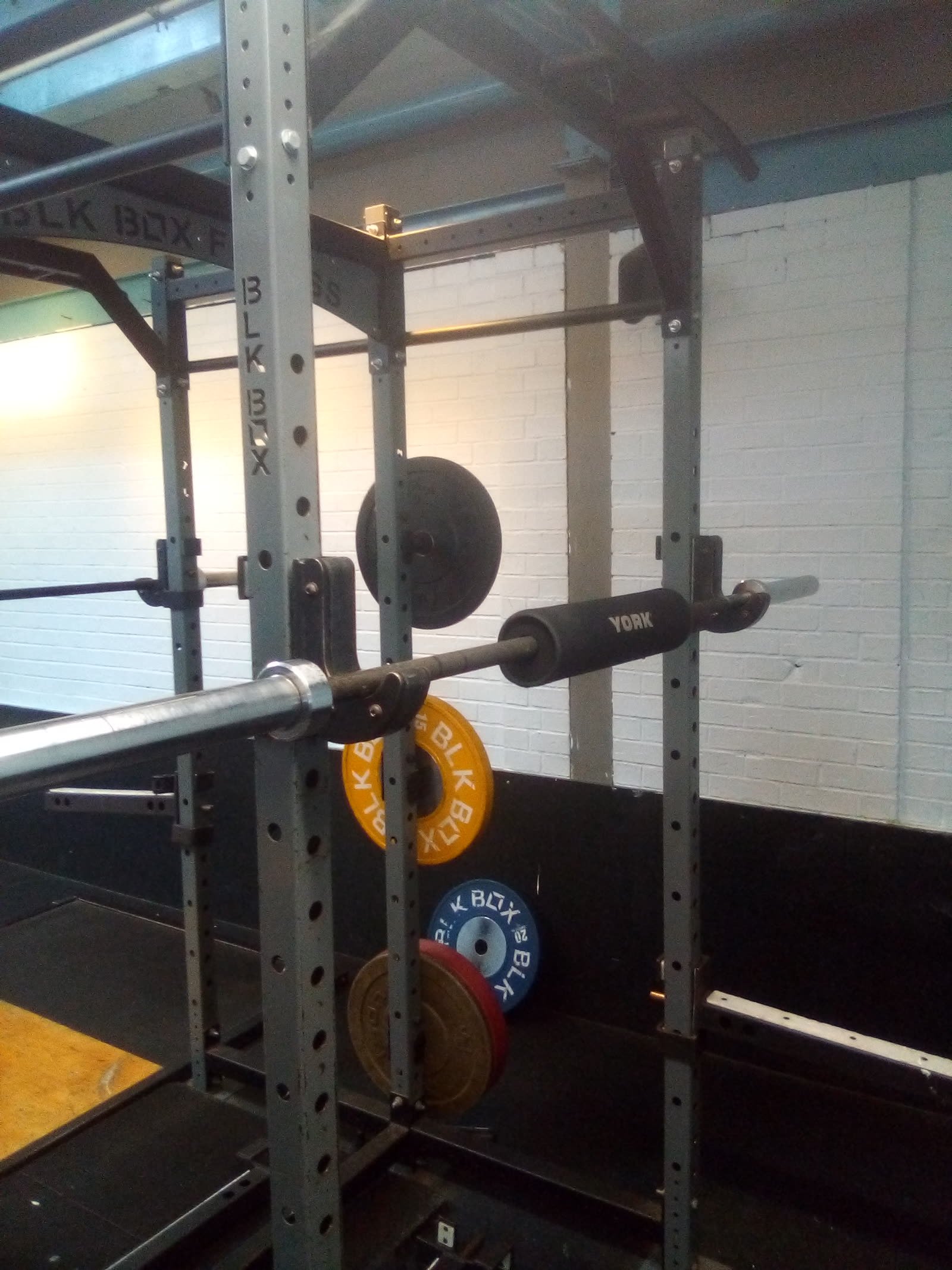 A loaded bar resting in a power rack