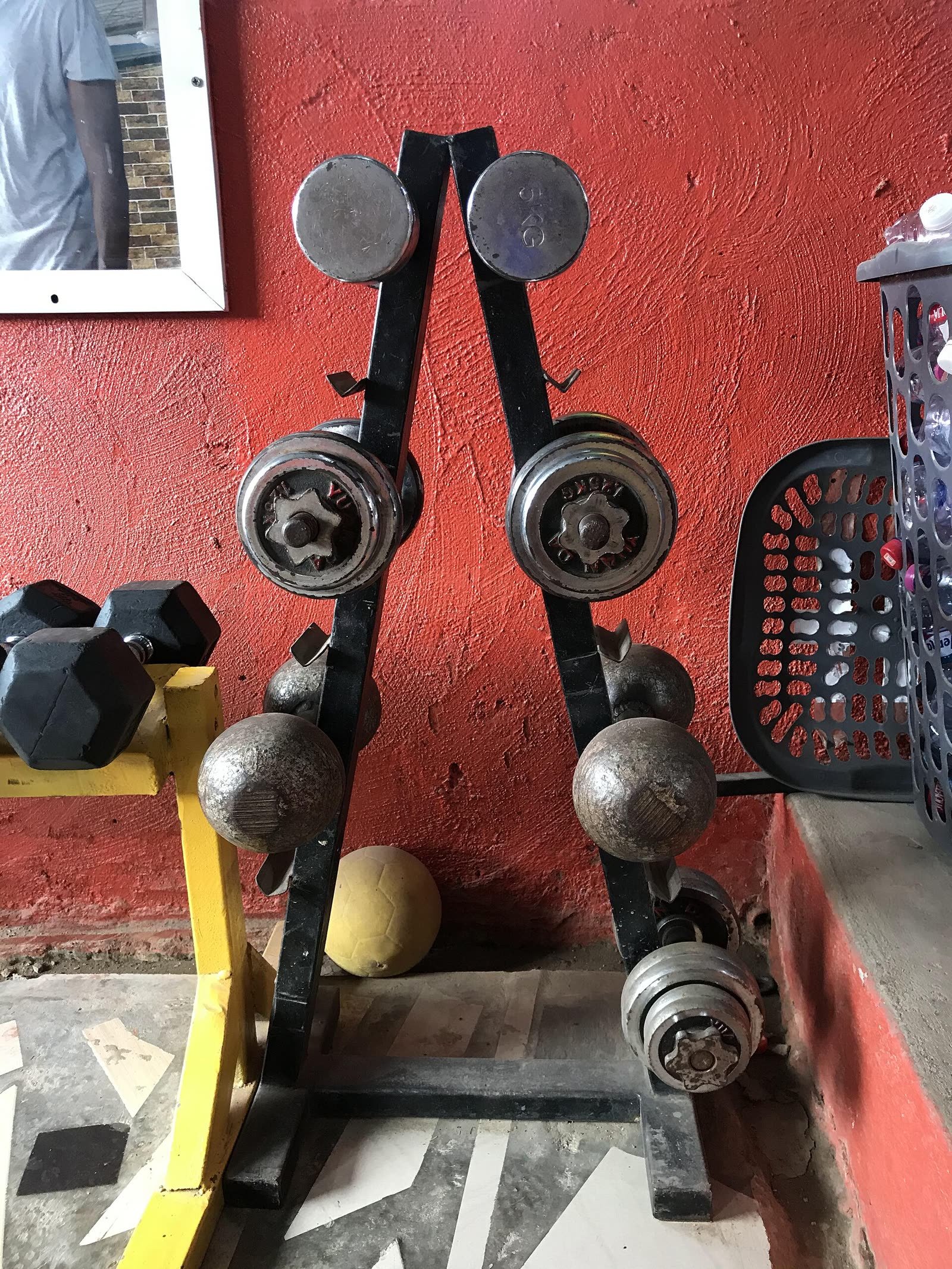 Small iron plates and dumbbells on a rack
